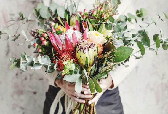 More flowers A person holding a vibrant bouquet of various flowers and greenery.