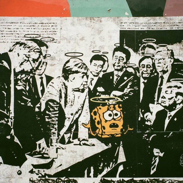 A black-and-white photo of a group of people with a bright cartoon character in the centre.